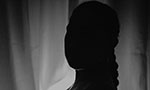 Foto em preto e branco: silhueta de uma mulher grávida.
