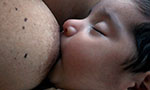 Foto de um bebê sendo amamentado.