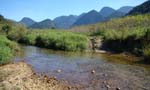 Rio com montanhas ao fundo.