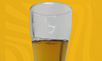 Copo com a cerveja produzida no experimento à frente de um fundo gerado no Canva.