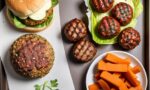 Imagem gerada por inteligência artificial de uma mesa com um lanche de hamburger, algumas carnes de hamburger, cenouras e folhas de alface