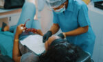 Fotografia de uma jovem sendo atendida por uma dentista.